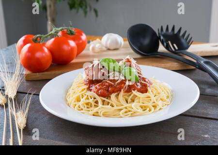 Piatto di spaghetti con sugo di pomodoro, polpette e basilico Foto Stock