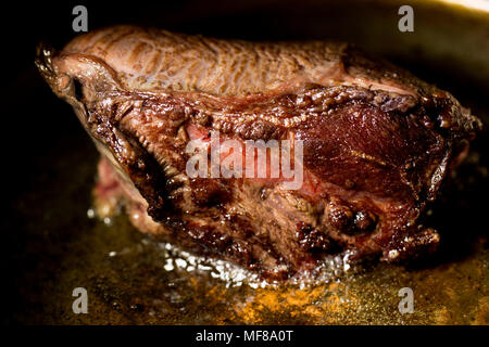 Un bue guancia da un supermercato la rosolatura in rame in padella prima di essere immessi in uno slow cooker con verdure miste, erbe e un brodo di manzo Foto Stock