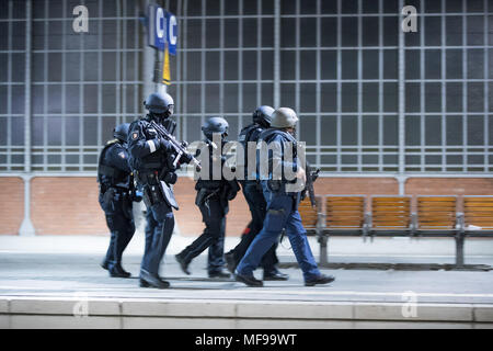 24 aprile 2018, Germania, Lubecca: gli ufficiali di polizia a piedi attraverso una piattaforma durante una dimostrazione di stampa per un anti-terrorismo esercizio a Lubecca stazione. Quasi 700 funzionari di polizia di stato e paese nonché circa 120 task force dei vigili del fuoco e i servizi di emergenza stanno prendendo parte a questo esercizio presso la stazione principale. Foto: Christian Charisius/dpa Foto Stock