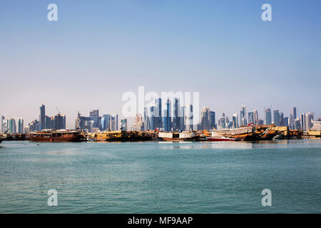 Doha West Bay skyline con acqua e barche Dhow in primo piano, preso dal porto. Foto Stock
