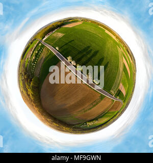 Piccolo pianeta panorama di una strada di campagna in Franconia, Baviera, Germania. Alberi fioriti gettare ombre lunghe in basso in piedi sun. Vista aerea. Foto Stock