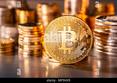 Moneta del cripto-moneta Bitcoin con diverse pile di monete in background Foto Stock