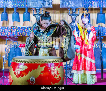 Due donne cinesi musicisti in kimono, una riproduzione di un grande tamburo rosso, l'altra parte di cembali, durante una performance presso la Torre del Tamburo, Xian, Cina. Foto Stock