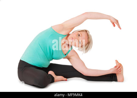 Corpo pieno vista di una giovane donna bionda facendo esercizi yoga di fronte a uno sfondo bianco con leggera ombra. Foto Stock