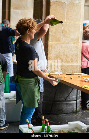 San Sebastian, Spagna - 2 settembre 2017. Cameriera versando il sidro di mele da una altezza, la più tipica bevanda alcolica nel Paese Basco. Donostia. Spagna Foto Stock