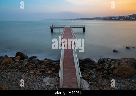 Una lunga esposizione di un molo presa al tramonto in Estepona un piccolo paese di pescatori sulla Costa del Sol in Spagna. Foto Stock