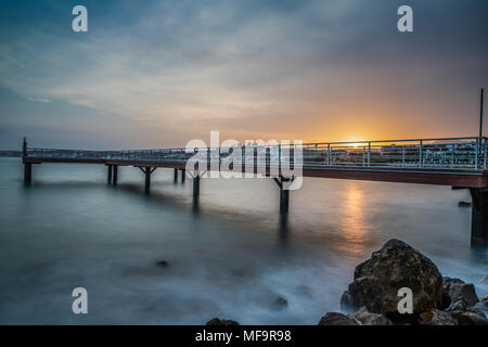 Una lunga esposizione di un molo presa al tramonto in Estepona un piccolo paese di pescatori sulla Costa del Sol in Spagna. Foto Stock