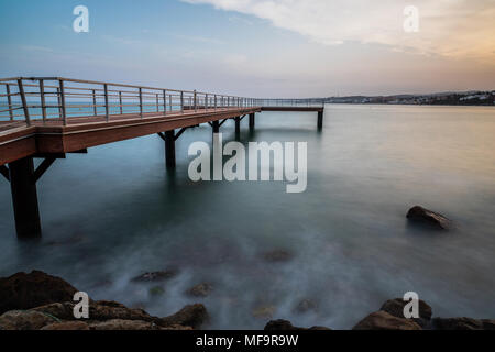 Una lunga esposizione di un molo presa al tramonto in Estepona un piccolo paese di pescatori sulla Costa del Sol in Spagna. Foto Stock