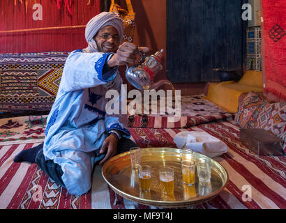 Un riff uomo in abito tradizionale versa il tè alla menta, Tinghir, Alto Atlante, Marocco Foto Stock
