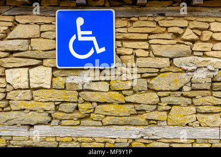 Cartello stradale che indica il parcheggio per le persone con disabilità appeso sulla pietra grezza parete, Accesso disabili segno, Accesso facilitato per portatori di Nandicap segno Foto Stock