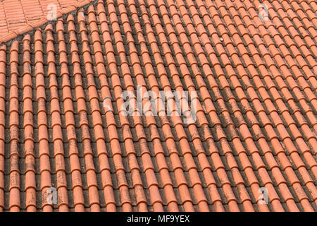 Vista superiore della vecchia e argilla spiovente tetto di tegole, pattern di piastrelle di colore arancione Foto Stock