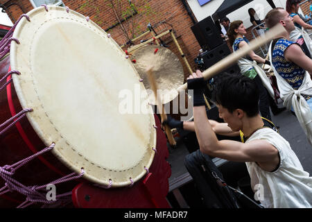 Battendo musicista giapponese ampio ō-daiko tamburo con bastoncini di bachi per Joji Hirota & London Taiko batteristi a Whitton St. George's Day Festival 2018 Foto Stock