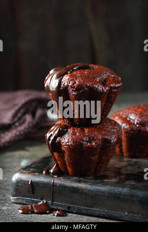 Il cioccolato muffin alla banana e rabboccato con cioccolato fuso, shot con luce naturale Foto Stock