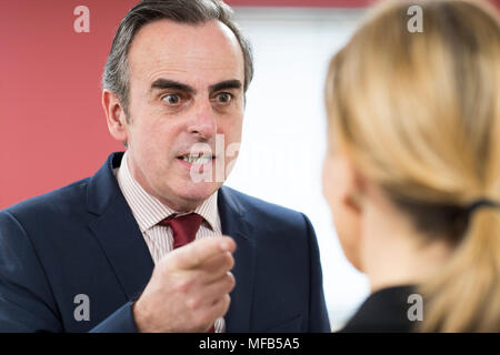 Imprenditore aggressivo grida al collega di sesso femminile Foto Stock