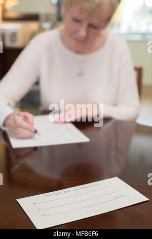 Senior donna firma Testamento, a casa Foto Stock