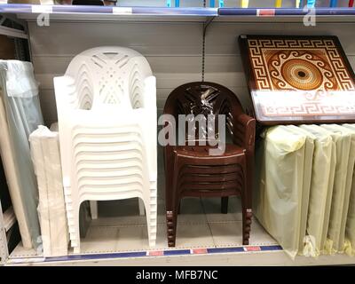 Impilati in righe di sedie di plastica sono pronti per la vendita in negozio. Foto Stock