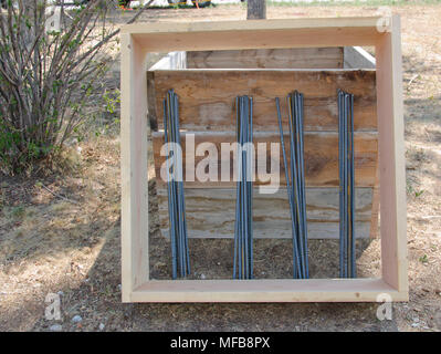 Il legno e rebar necessari per creare le forme concrete per la fondazione di una casa di sedersi pronto per essere utilizzato. Foto Stock