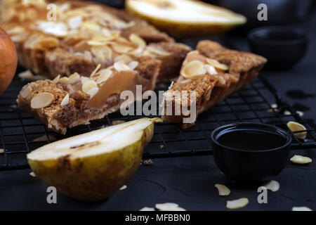 Frangipane crostata con pere in camicia e petali di mandorle. Tasto basso. Foto Stock