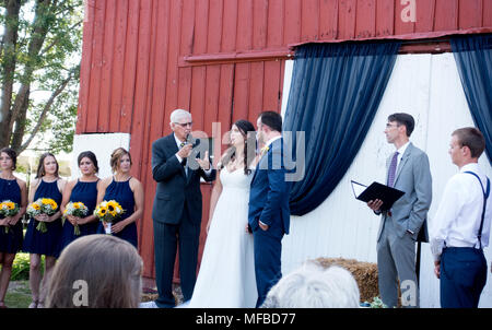 Il ministro lo scambio di promesse di matrimonio con la sua nipote la sposa e lo sposo eseguita in una fattoria impostazione. Champaign Illinois IL USA Foto Stock