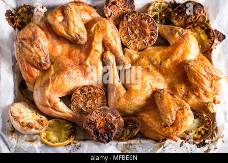 Flattaned fuori golden arrosto di pollo con limone e aglio. Vista dall'alto. Foto Stock
