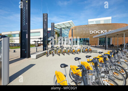 Bruxelles, Belgio, 19 aprile 2018: Stock di noleggio bici e alcune persone in appoggio al Dock Bruxsel entrata principale - Nuovo quartiere commerciale, in un'area Foto Stock