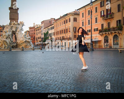 Giovane ragazza danzante in un abito nero di mattina in Piazza Navona, Roma, Italia Foto Stock