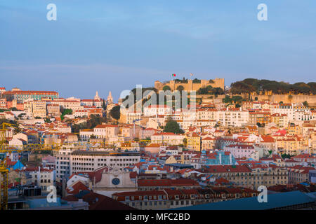 Lo skyline di Lisbona, vista del Castelo de Sao Jorge al tramonto con le affollate hillside edifici del quartiere Mouraria situati al di sotto, Lisbona, Portogallo. Foto Stock