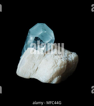 Blu cristallo trasparente di acquamarina di gemme in una matrice di bianco albite, isolata su uno sfondo nero Foto Stock