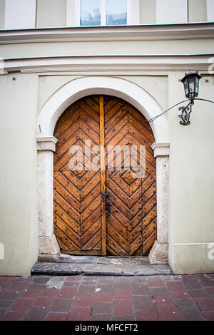 Vecchia porta di legno con serratura metallica e lucchetto, Cracovia in Polonia. Foto Stock