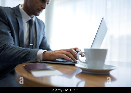 Ritagliato shot di imprenditore mani digitando sulla tastiera del notebook. Uomo che utilizza il computer portatile in ufficio. Foto Stock