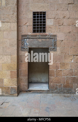 Esterno antico vecchi mattoni decorata con mura in pietra e porta aperta che conduce a Beit (casa) Al Sehemy storica casa al Cairo, Egitto Foto Stock