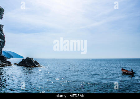 Pescatore solitario su una barca in mare aperto in una giornata di sole Foto Stock