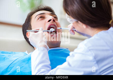 Donna dentista medico con il paziente di sesso maschile in ospedale Foto Stock