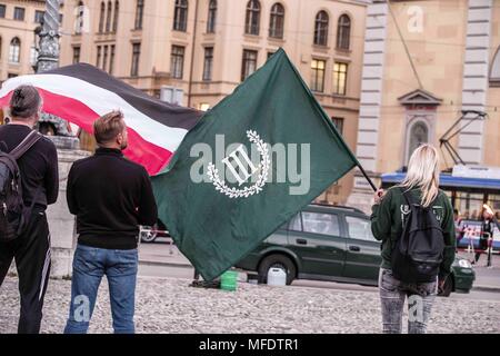 Monaco di Baviera, Germania. Xxv Aprile, 2018. Il militante, estremisti neo-nazi gruppo III. Weg (dritter Weg, terzo percorso) hanno tenuto il loro memoriale annuale per Reinhold Elstner, un neo-nazi che sono morti a causa di un'auto-immolazione nel 1995. In presenze è stato terrorista Karl-Heinz Statzberger, che è stato condannato per il tentativo di bombardare la Sinagoga di Monaco di Baviera. Il gruppo detiene questa cerimonia annualmente a Max Joseph Platz, nella parte anteriore della Staatsopera e celebre Residenz, che appendere striscioni in opposizione al gruppo. Credito: Sachelle Babbar/ZUMA filo/Alamy Live News Foto Stock