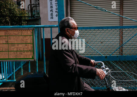 Il vecchio uomo in sella ad una bicicletta su una strada. Foto Stock