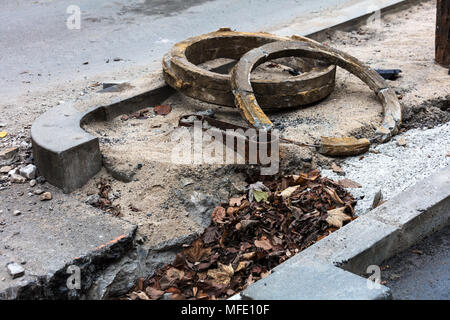 Portelli riparazione di strada non protetta tombino fognario in strada Foto Stock