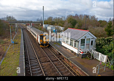 Acle stazione ferroviaria sulla Wherry linee tra Norwich e Great Yarmouth in Norfolk, Regno Unito con una classe BR 153 DMU avvicinando il signalbox Foto Stock