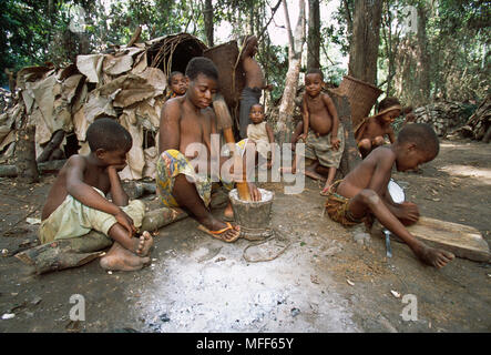 La famiglia dei Pigmei Baka di tribù preparare il cibo nel villaggio di Camerun e Repubblica Centrafricana Foto Stock