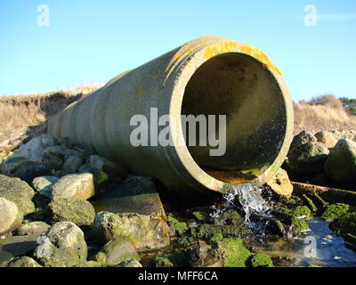 Calcestruzzo di cemento grigio tubo di scarico con il flusso di acqua Foto Stock