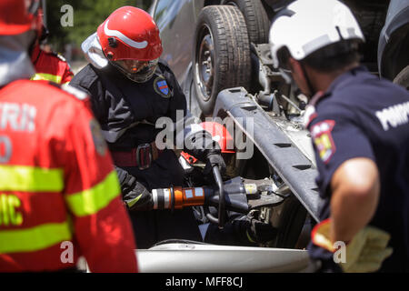 Salvataggio dei vigili del fuoco e paramedici prendere parte in un veicolo extrication presso un trapano car crash site Foto Stock