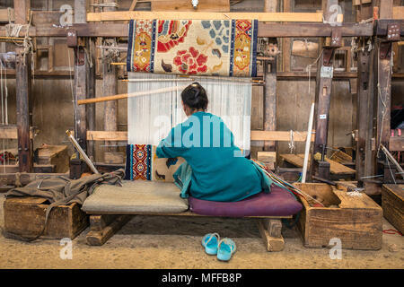 Darjeeling, India - 19 Aprile 2017: tibetano non identificato la donna lavora come tessitore nel tappeto officina dei rifugiati tibetani Self Help Center, Darjeeling, Foto Stock