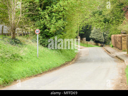 In East Midlands campagna di Inghilterra a primavera, a 30 MPH segno su una strada stretta che scende nel piccolo villaggio di Stoke asciutto. Foto Stock