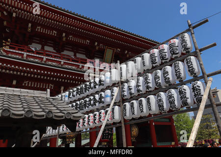 Enorme parete di carta bianca lanterne, chiamato anche chochin, nero con caratteri giapponesi sono appesi su una a 3 livelli di rack il tempio di Sensoji complessa, Tokyo Foto Stock