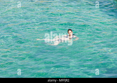 Cala Murada, Mallorca, Spagna - una giovane donna sorridente mentre si nuota nelle acque turchesi del Mar Mediterraneo a Cala Murada Foto Stock