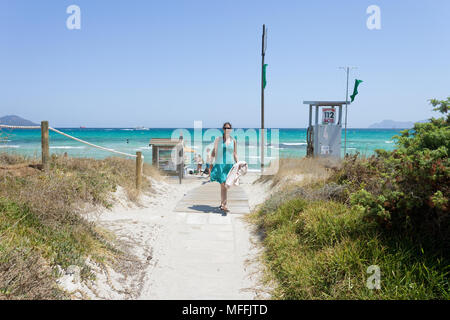 Platja de muro, Mallorca, Spagna - Agosto 2016 - Una giovane donna di ritorno dalla Spiaggia di Platja de Muro Foto Stock