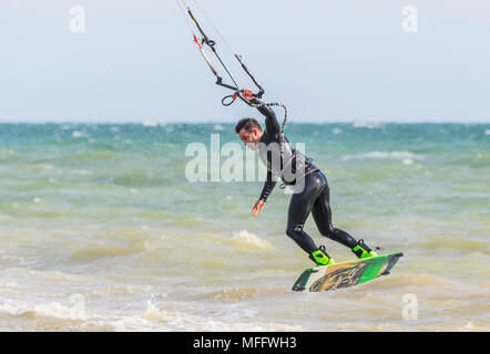 Uomo di Kitesurf in mare e prendendo il largo tenendo con una mano. Kitesurfer sull'oceano. Sport acquatici. Foto Stock