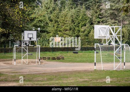 Parco giochi per bambini in una scuola, pallamano net e cesto net , circondato da erba Foto Stock