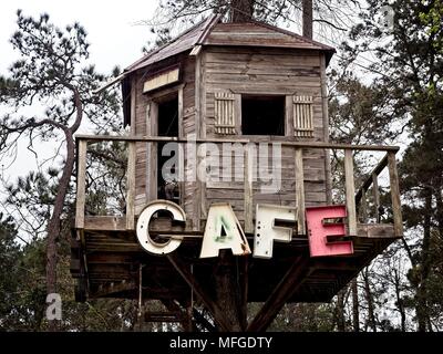 Cafe Sign on a Treehouse lungo una strada sopraelevata in Texas Foto Stock