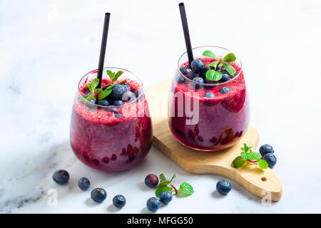 Spremuta di succo di mirtillo sul tavolo. una sana bevanda estiva in due bicchieri. Foto Stock