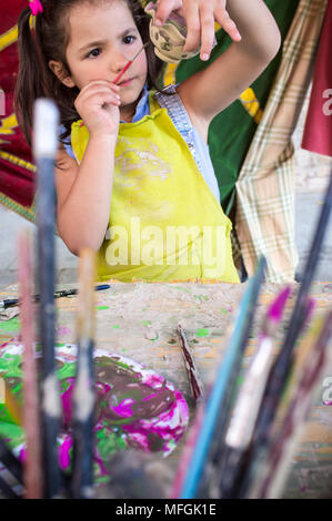 Bambino ragazza pittura piccolo pezzo di argilla. Laboratorio di ceramica per bambini concept Foto Stock